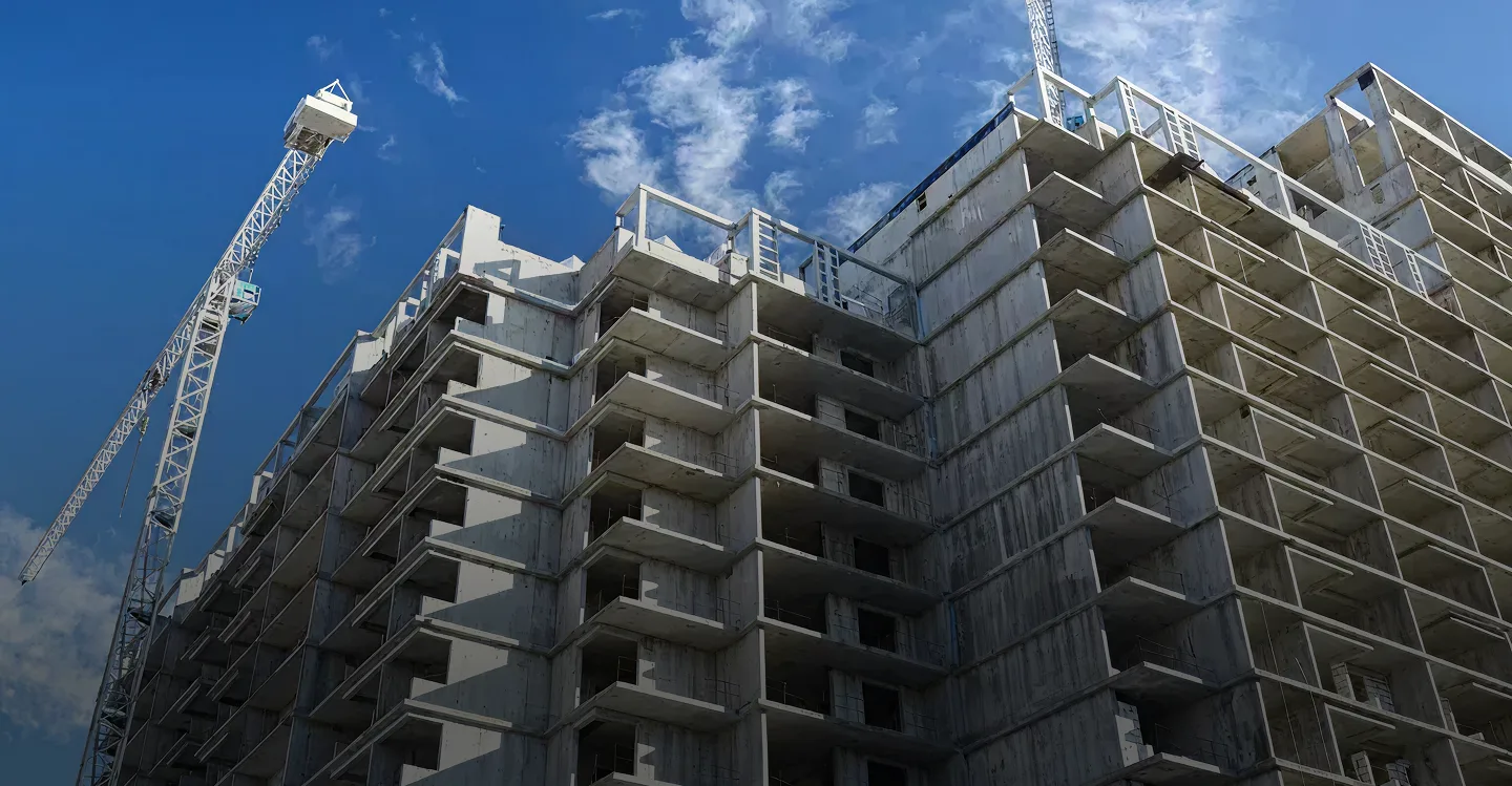 Concrete building under construction with cranes