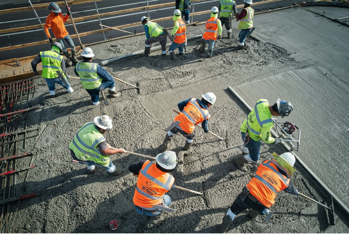 Concrete contractors working on dispersing the concrete.